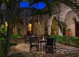 a patio with chairs and tables in the middle of a stone building