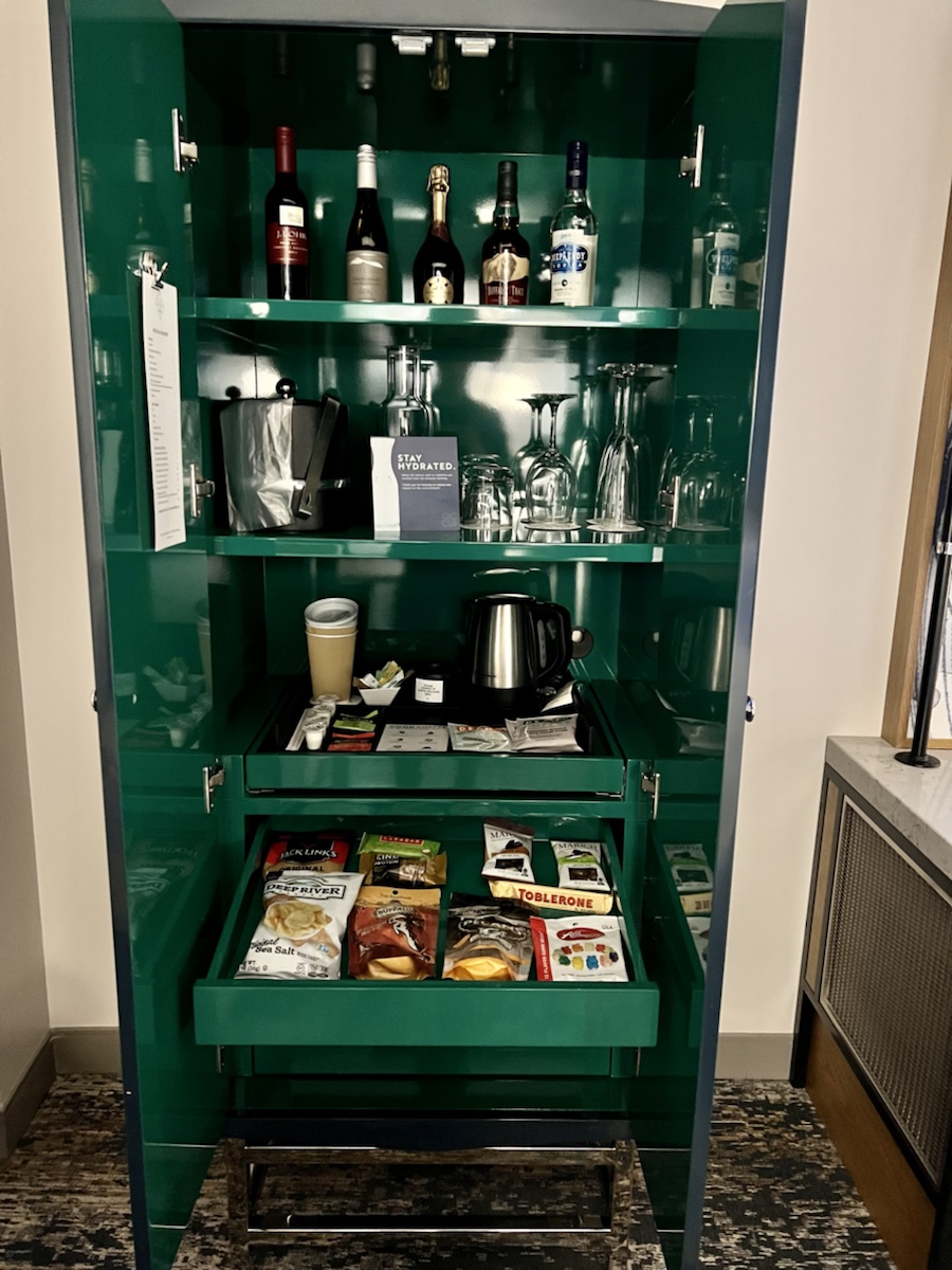a green cabinet with a shelf full of food and drinks