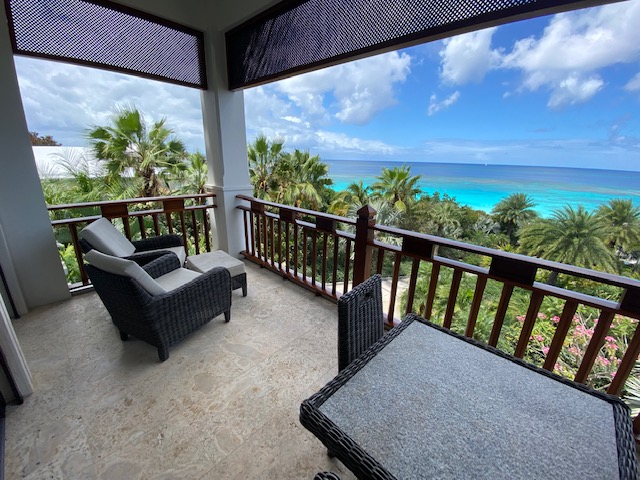 a deck with chairs and a view of the ocean