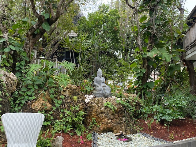 a statue on a rock surrounded by trees