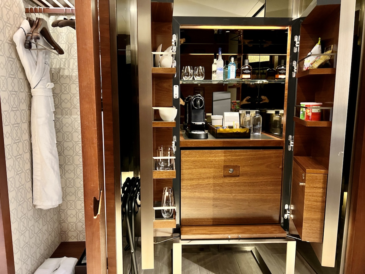 a cabinet with a coffee machine and glasses