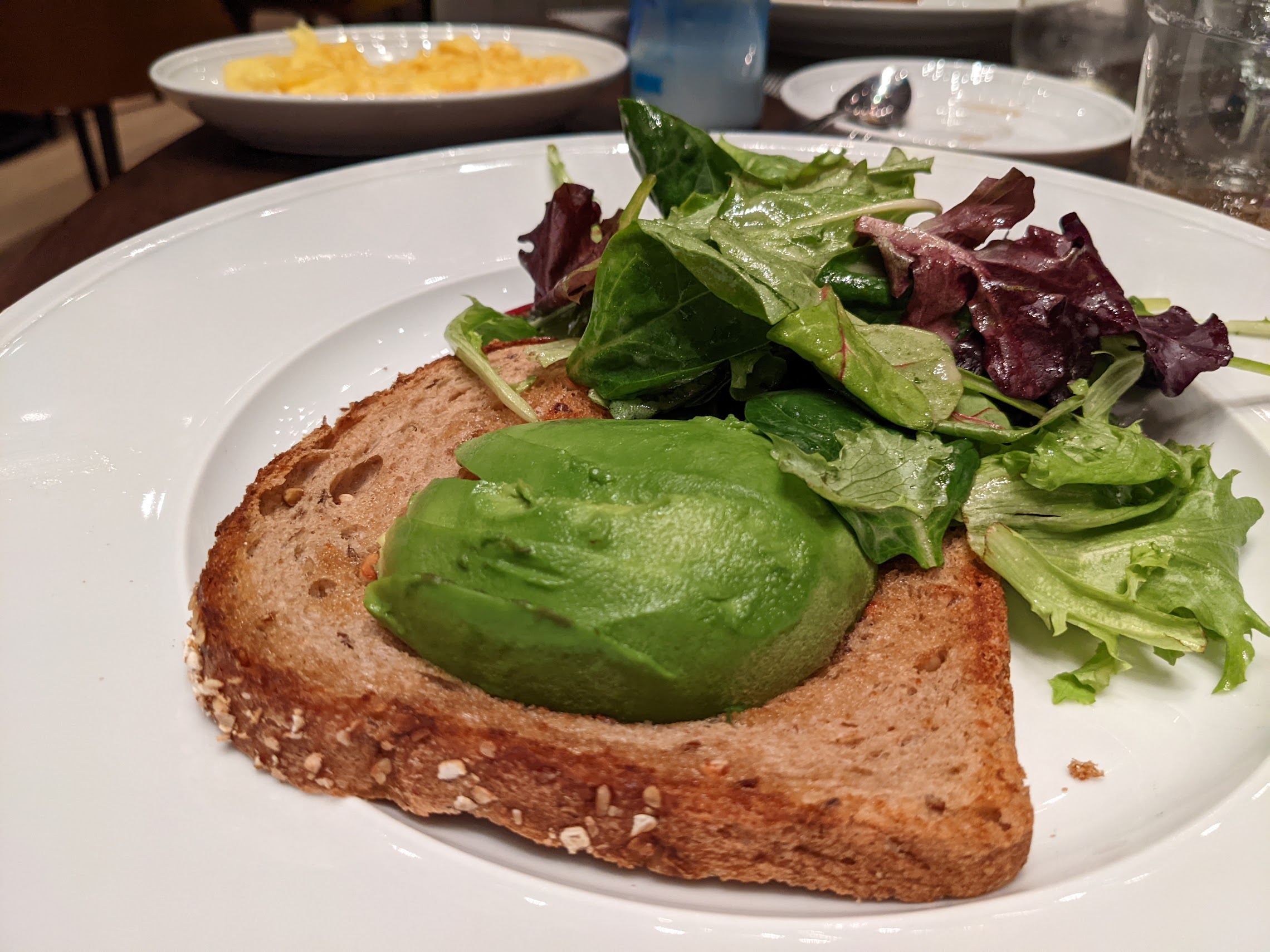 a plate of food with a green avocado on top