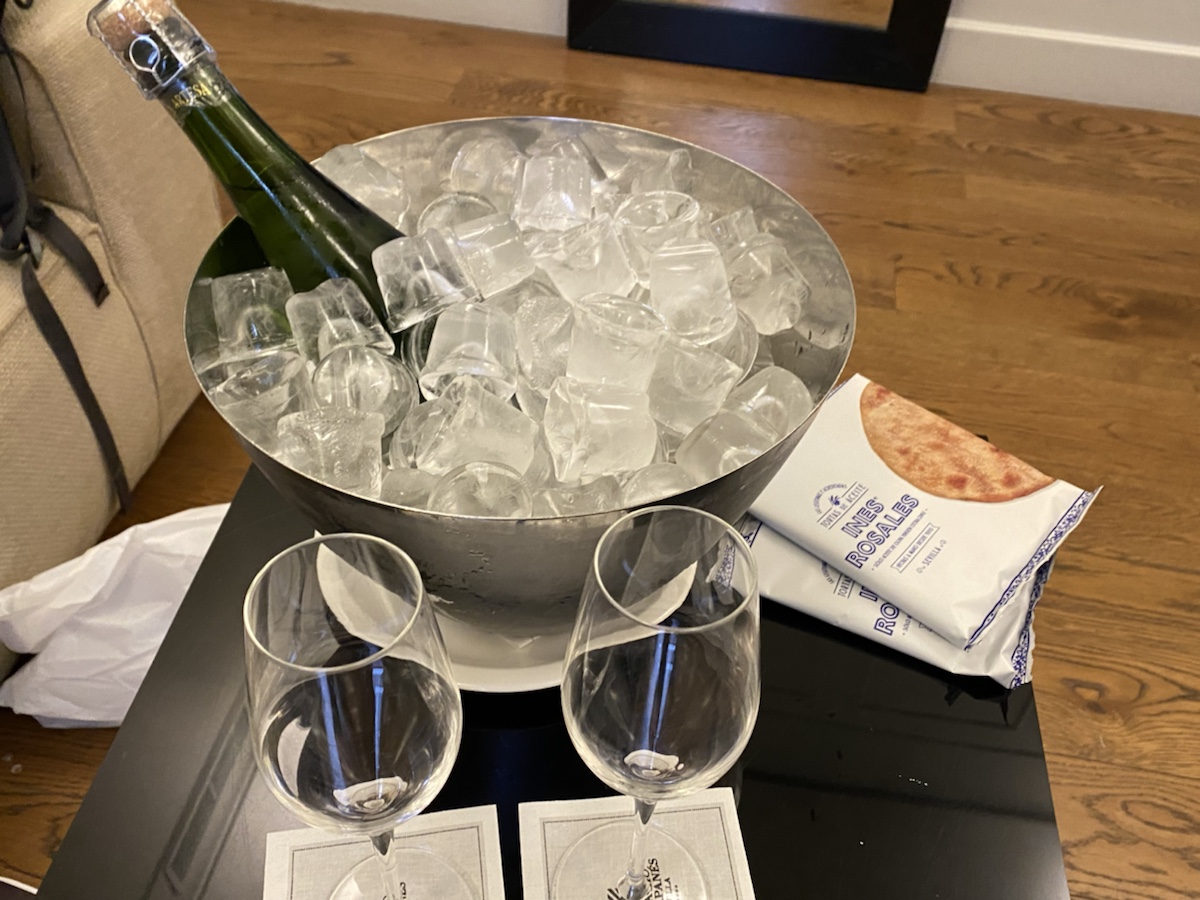 a champagne bottle in a bucket of ice and glasses on a table