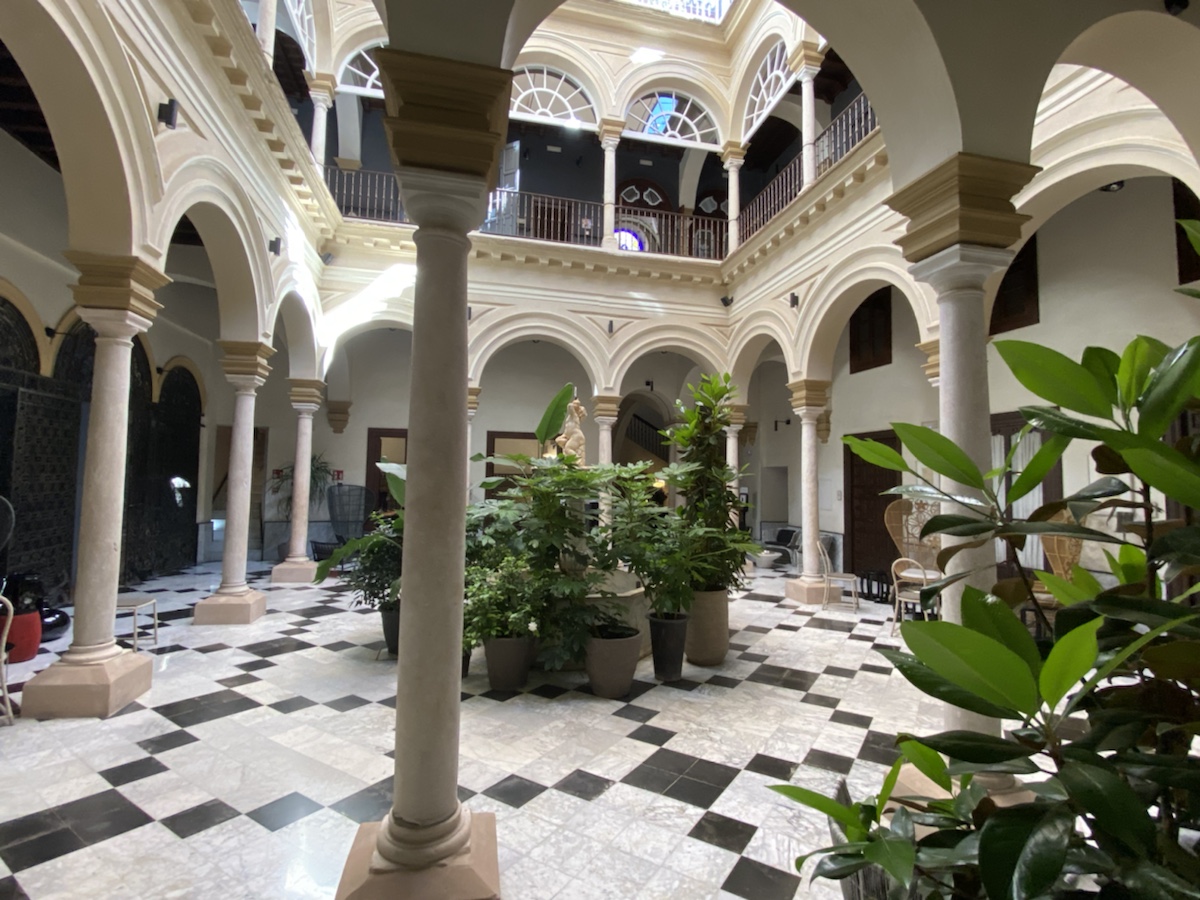a large indoor courtyard with columns and plants