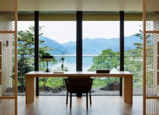 a desk and chair in a room with large windows