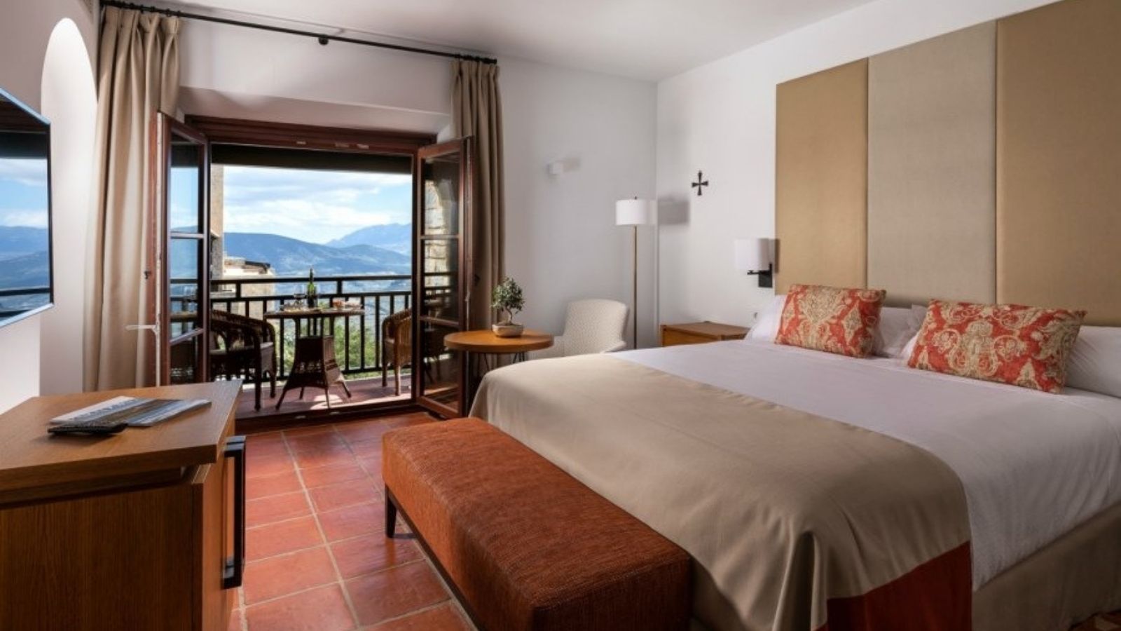 a bedroom with a view of mountains and a balcony