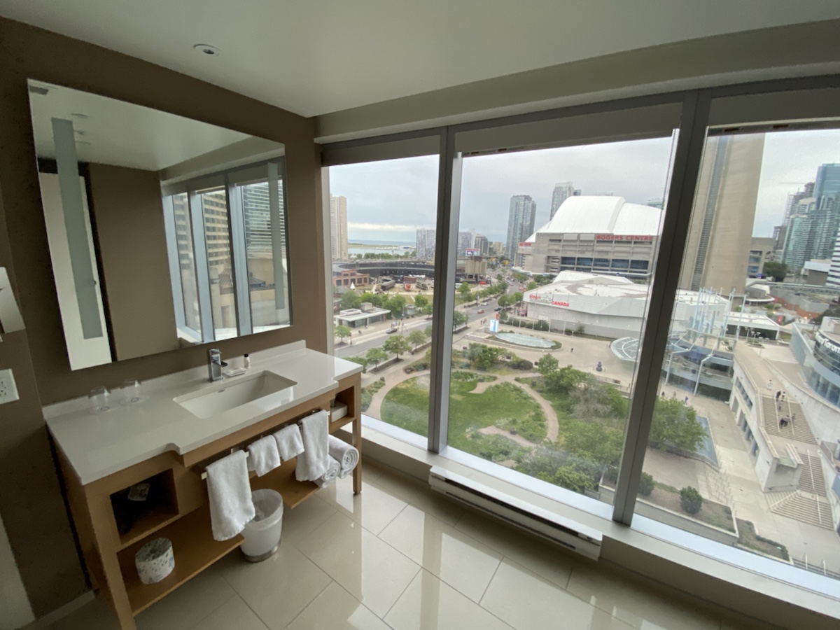 a bathroom with a large window and a city view