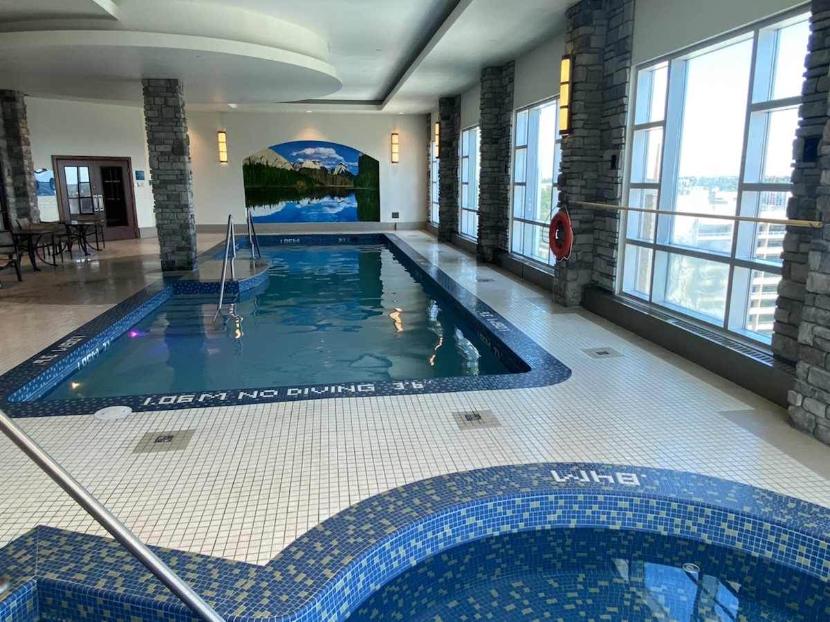 a indoor pool with a large wall and windows