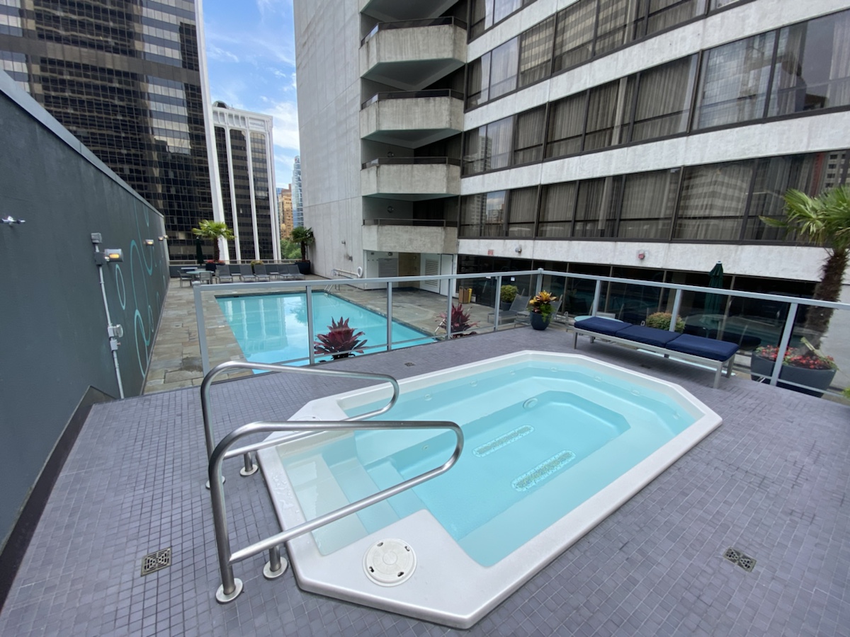 a pool on a rooftop with a building in the background