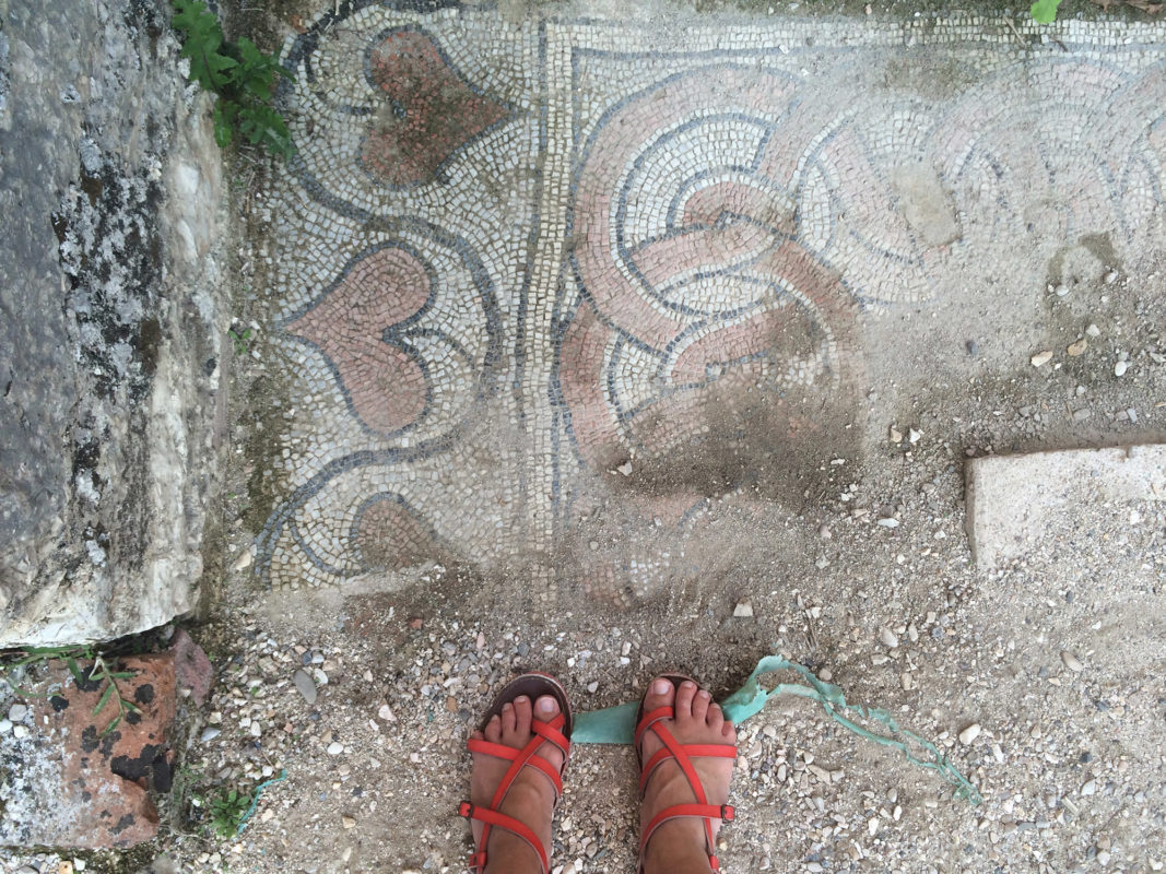 a person's feet standing on a stone surface