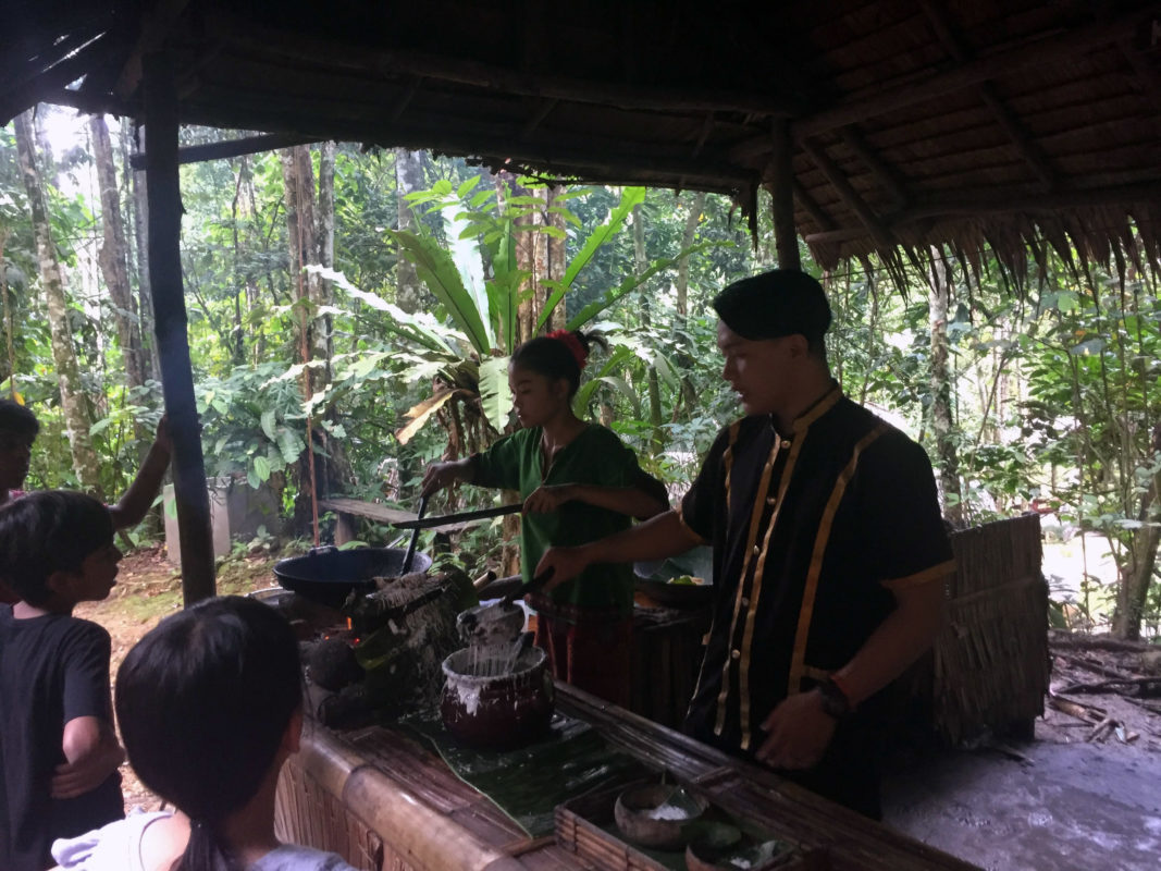a group of people cooking in a hut