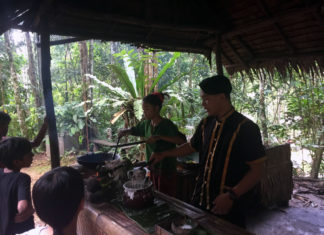 a group of people cooking in a hut