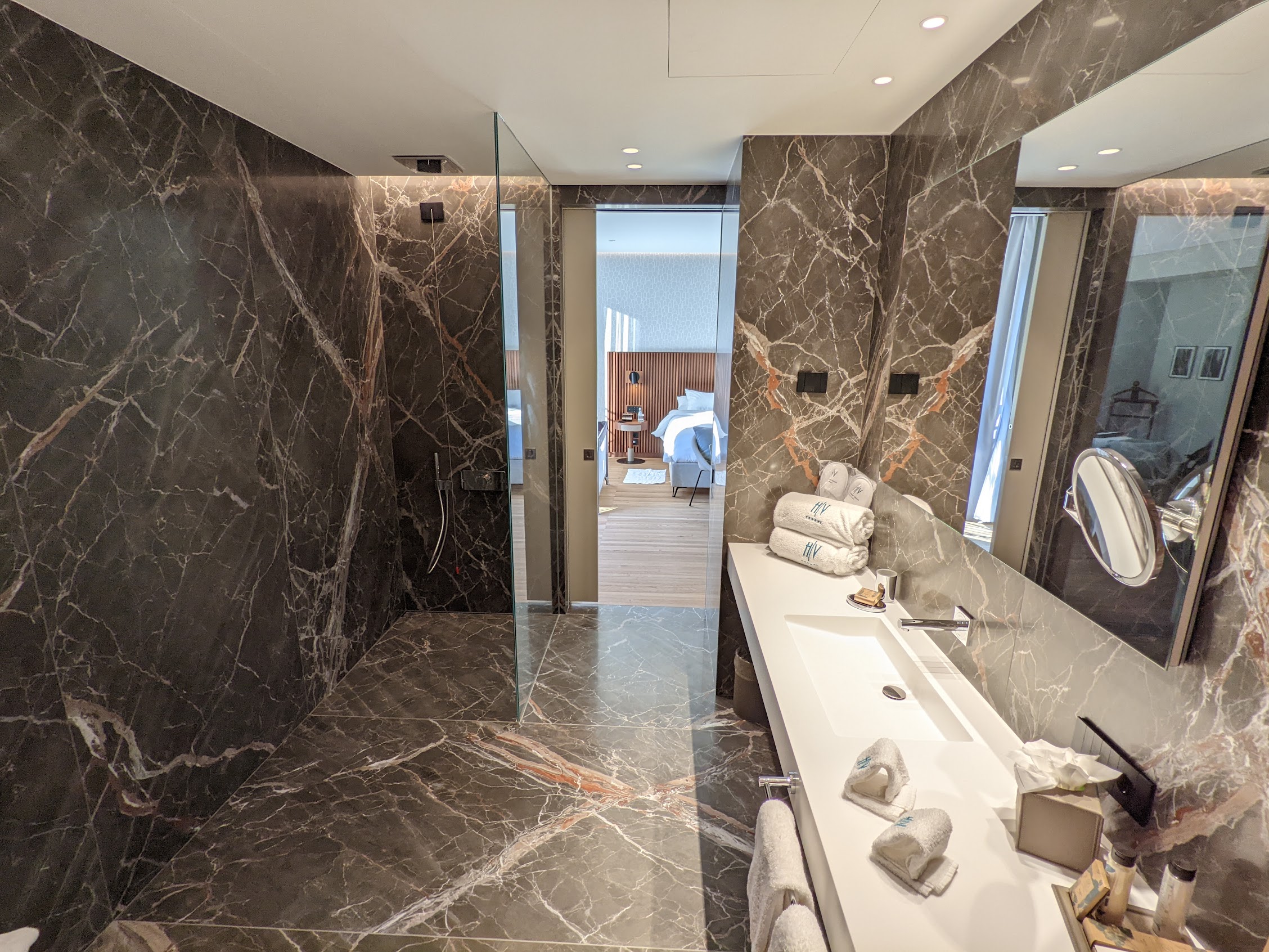 a bathroom with marble walls and a large mirror