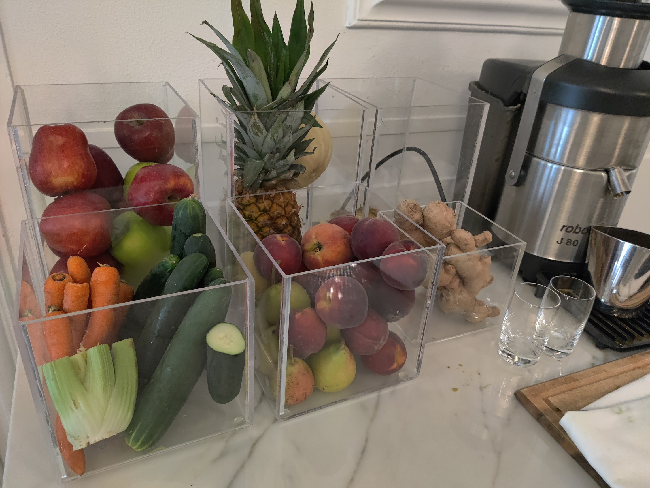 a group of clear containers with fruits and vegetables