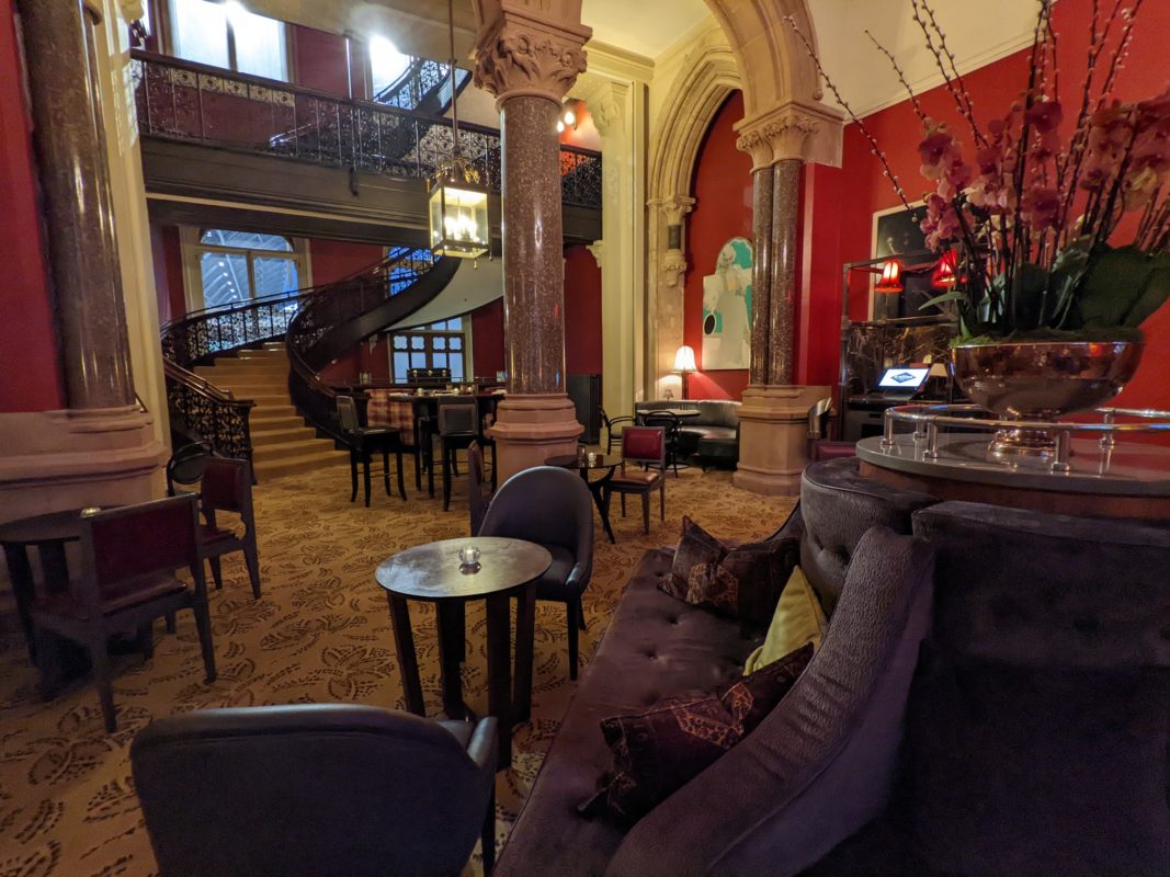 a room with a spiral staircase and tables and chairs