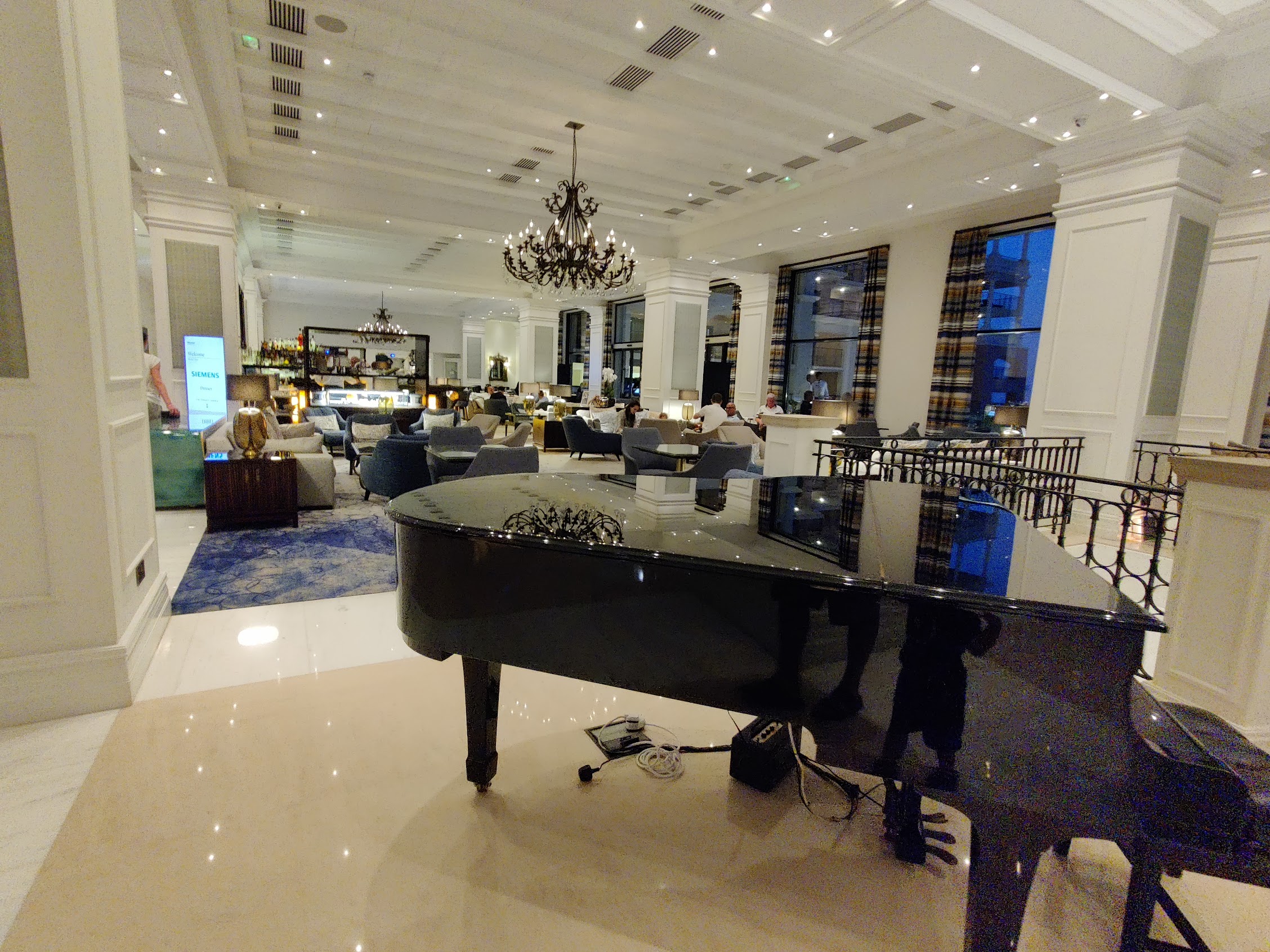 a large room with a piano and a chandelier
