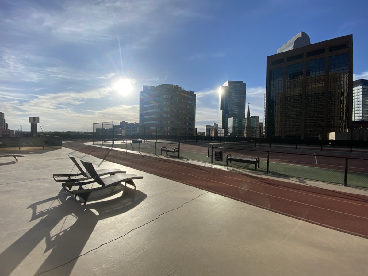 a tennis court with chairs and a city skyline