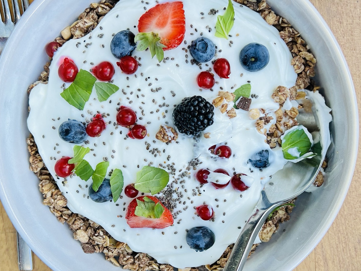 a bowl of yogurt with berries and a spoon