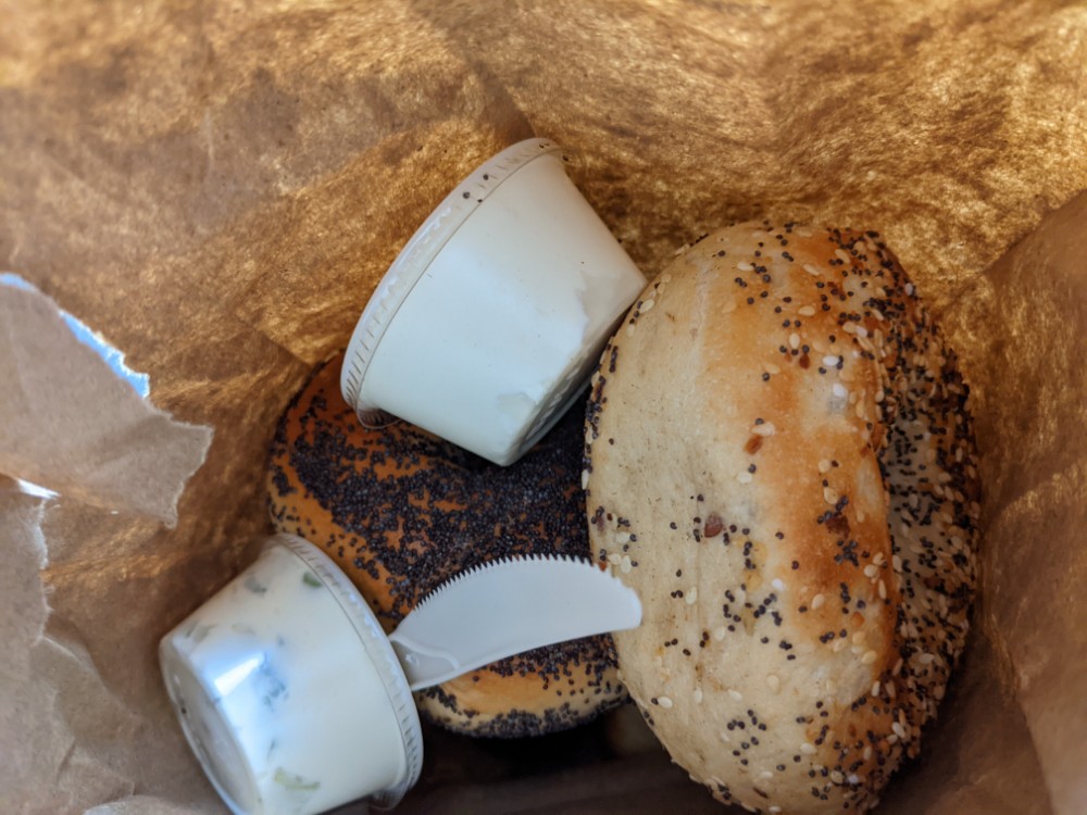 a bagel with a bagel and a cup of yogurt