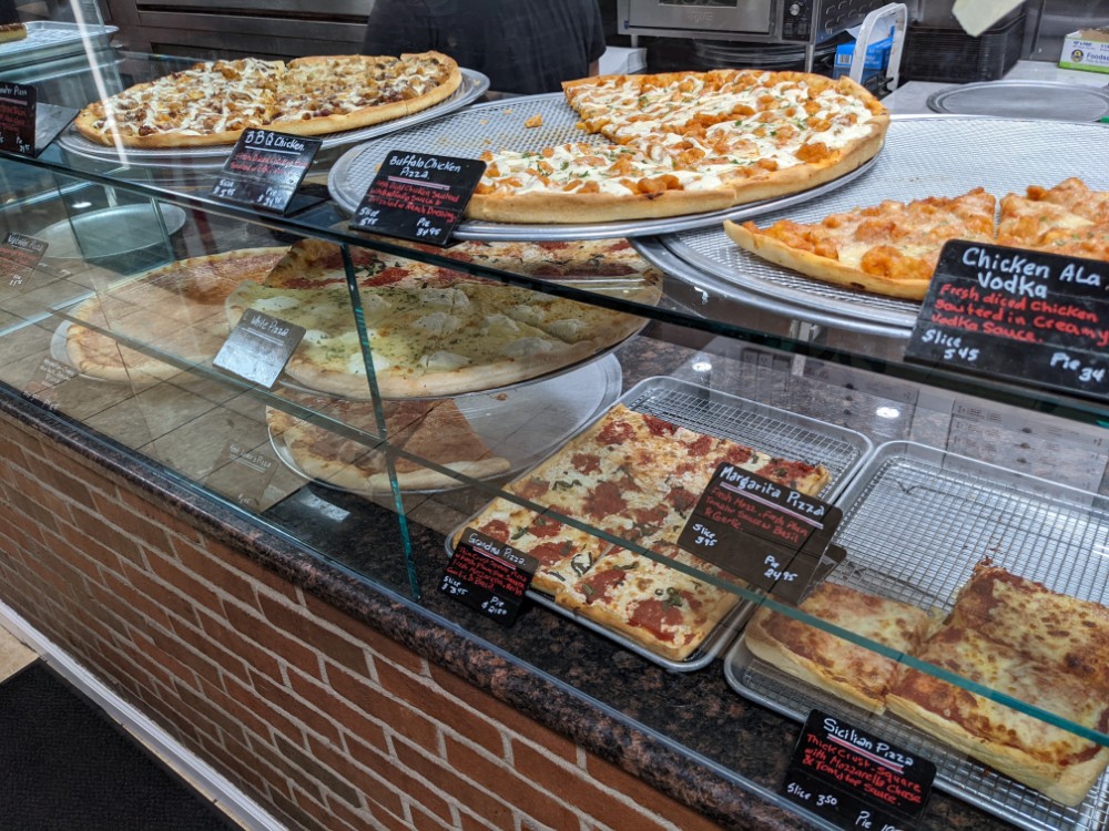 a display case with pizzas on it
