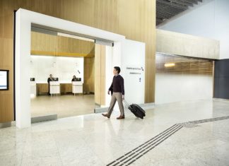 a man walking with luggage in a lobby