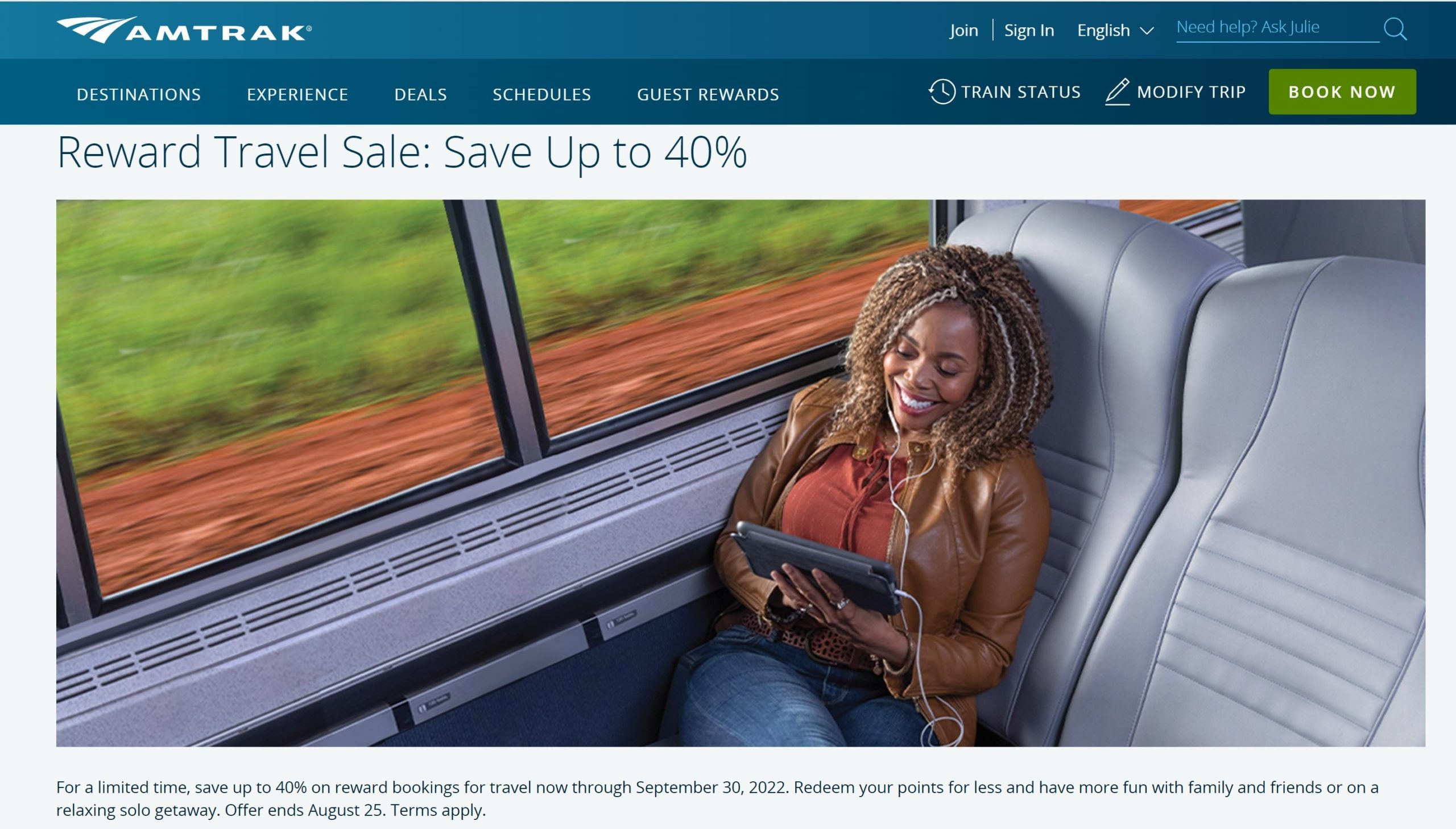 a woman sitting on a train looking at a tablet