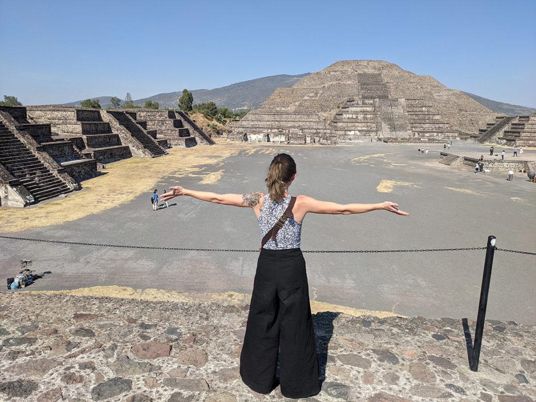 a woman standing in front of a pyramid