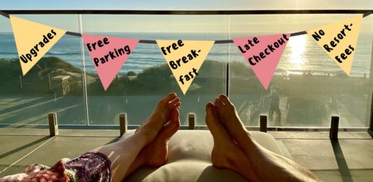 a person's feet on a couch with a flag from a balcony