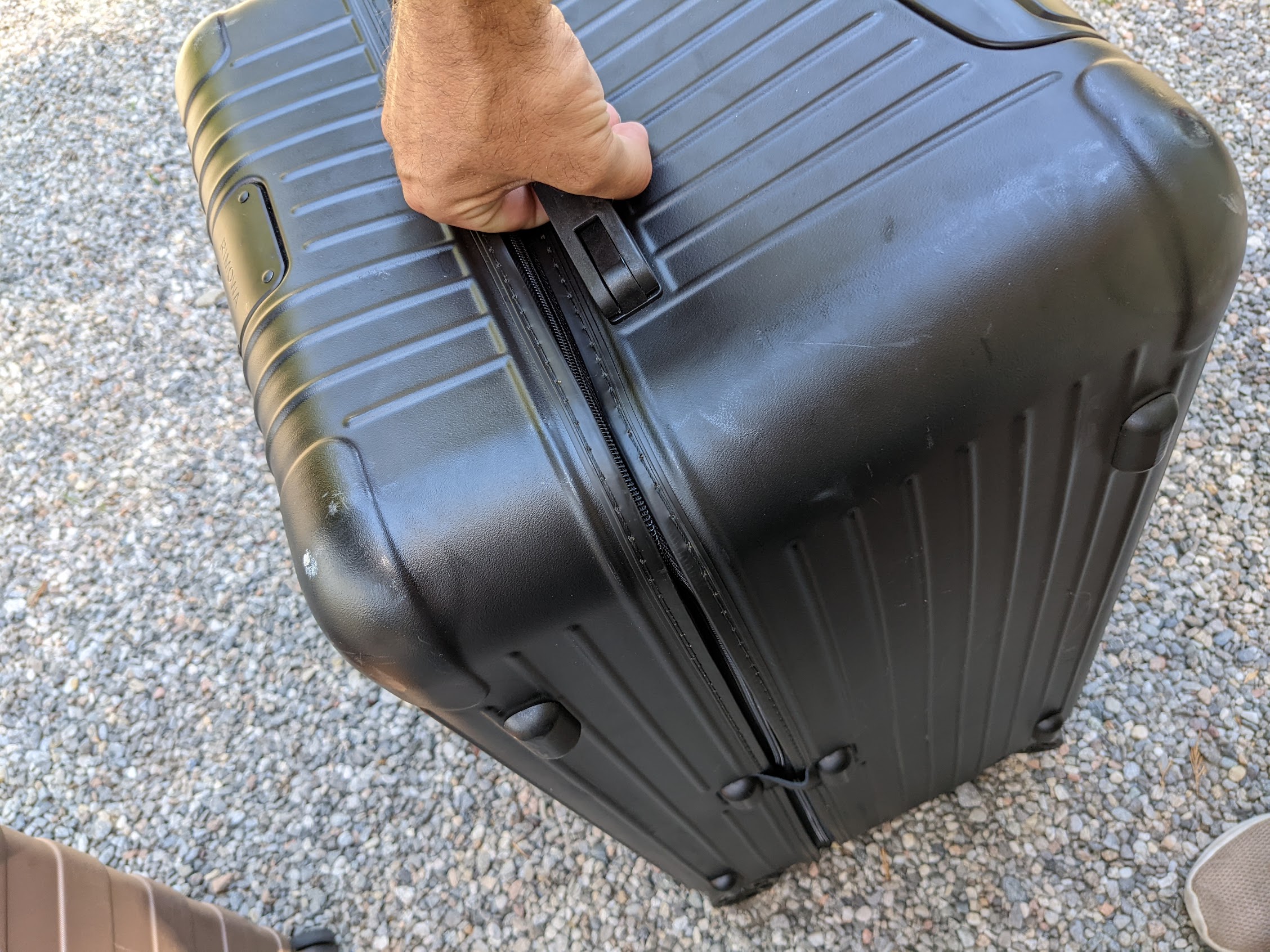 a hand holding a black suitcase