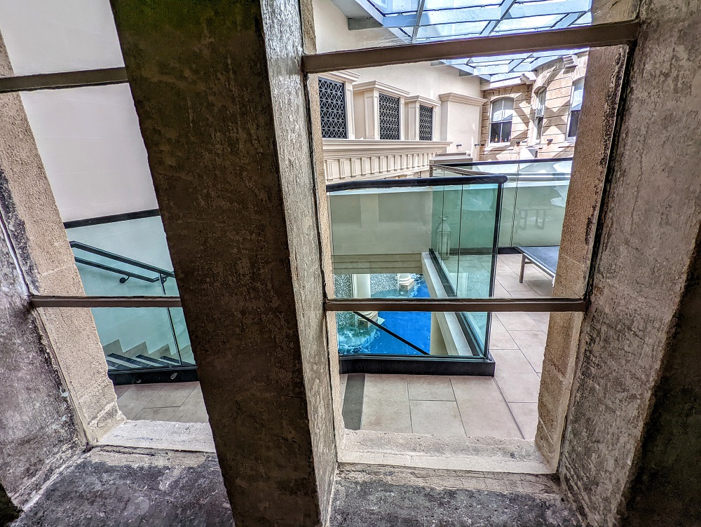 a glass wall with a staircase and a pool