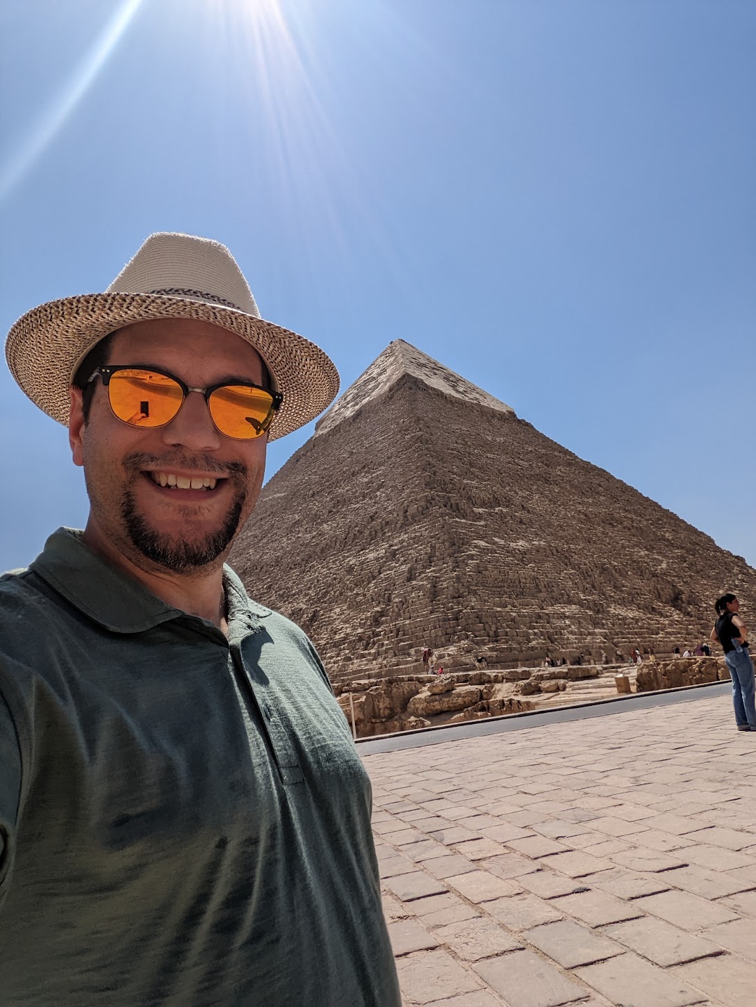 a man taking a selfie in front of a pyramid