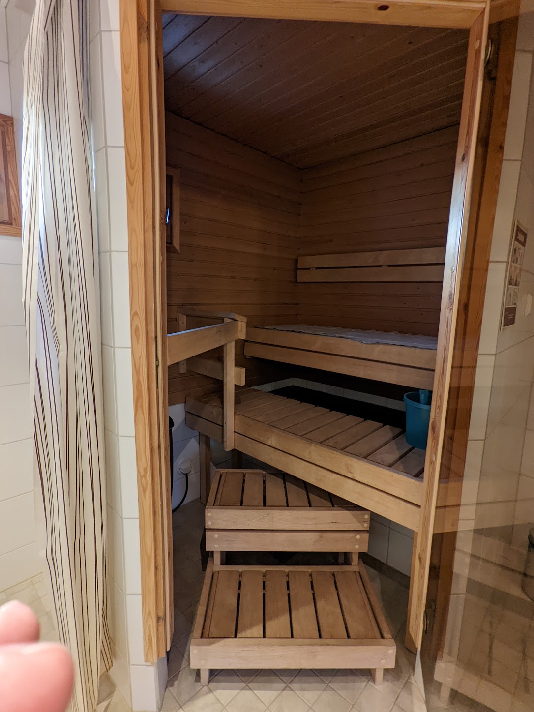 a wooden sauna with a bench and stool