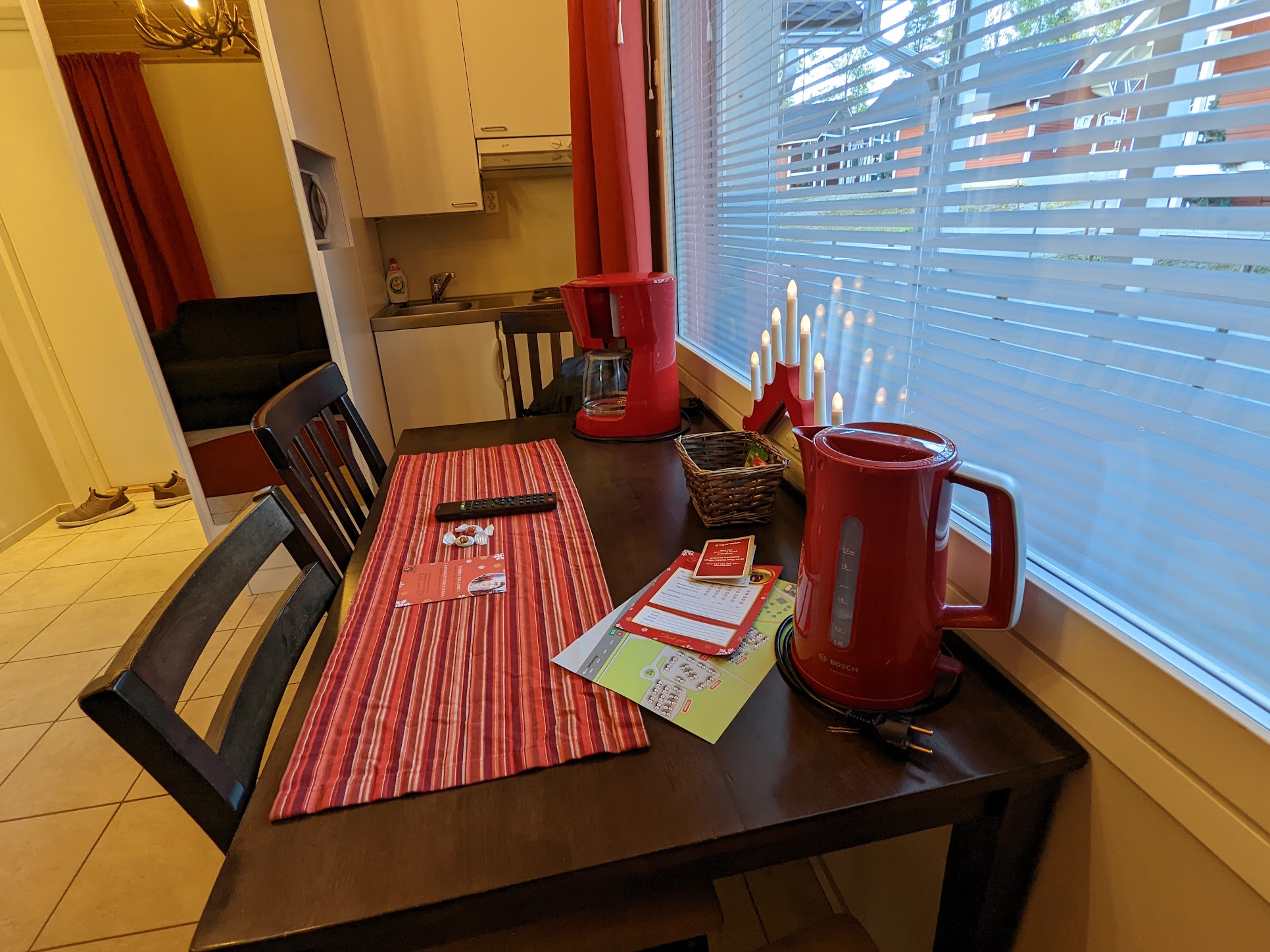a table with a red and white tablecloth and a red pitcher on it