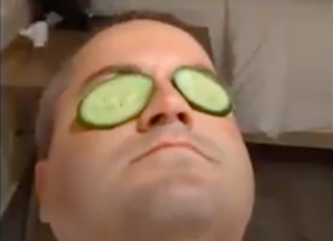 a man with cucumbers on his eyes