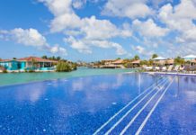 a swimming pool with a body of water and buildings