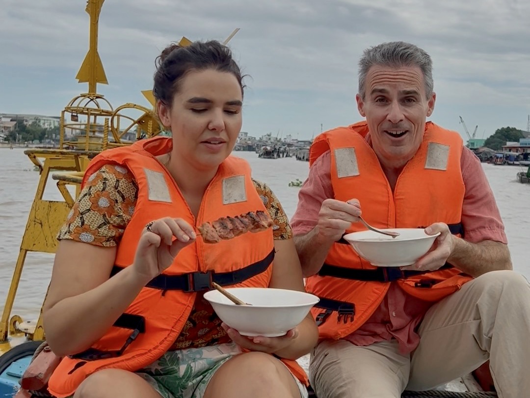 a man and woman in life jackets eating food