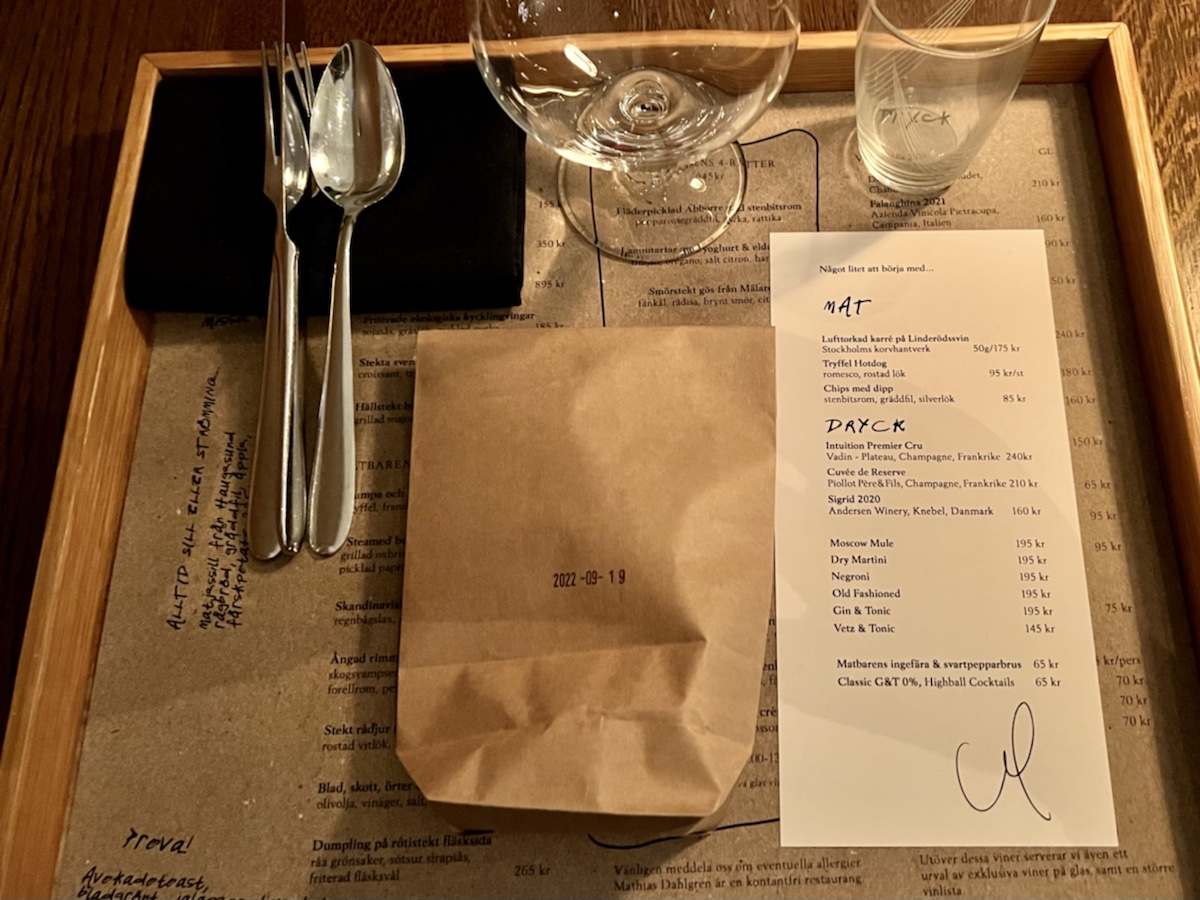 a tray with a paper bag and silverware on it