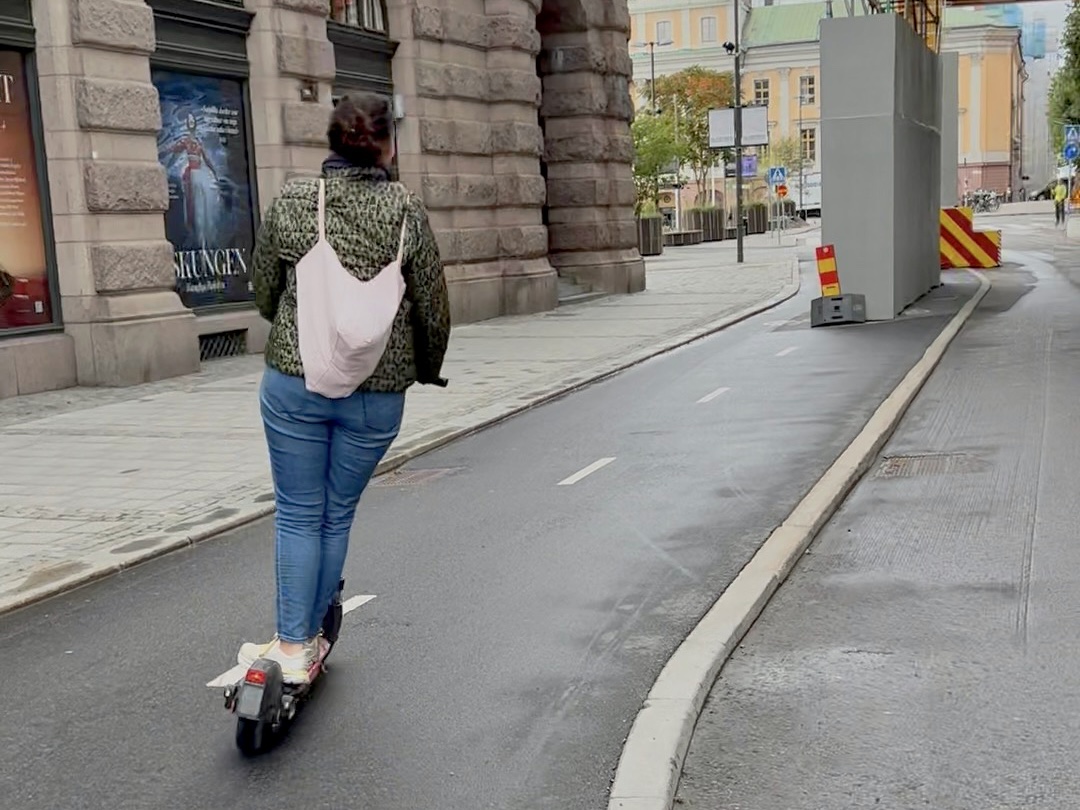 a woman riding a scooter on a street