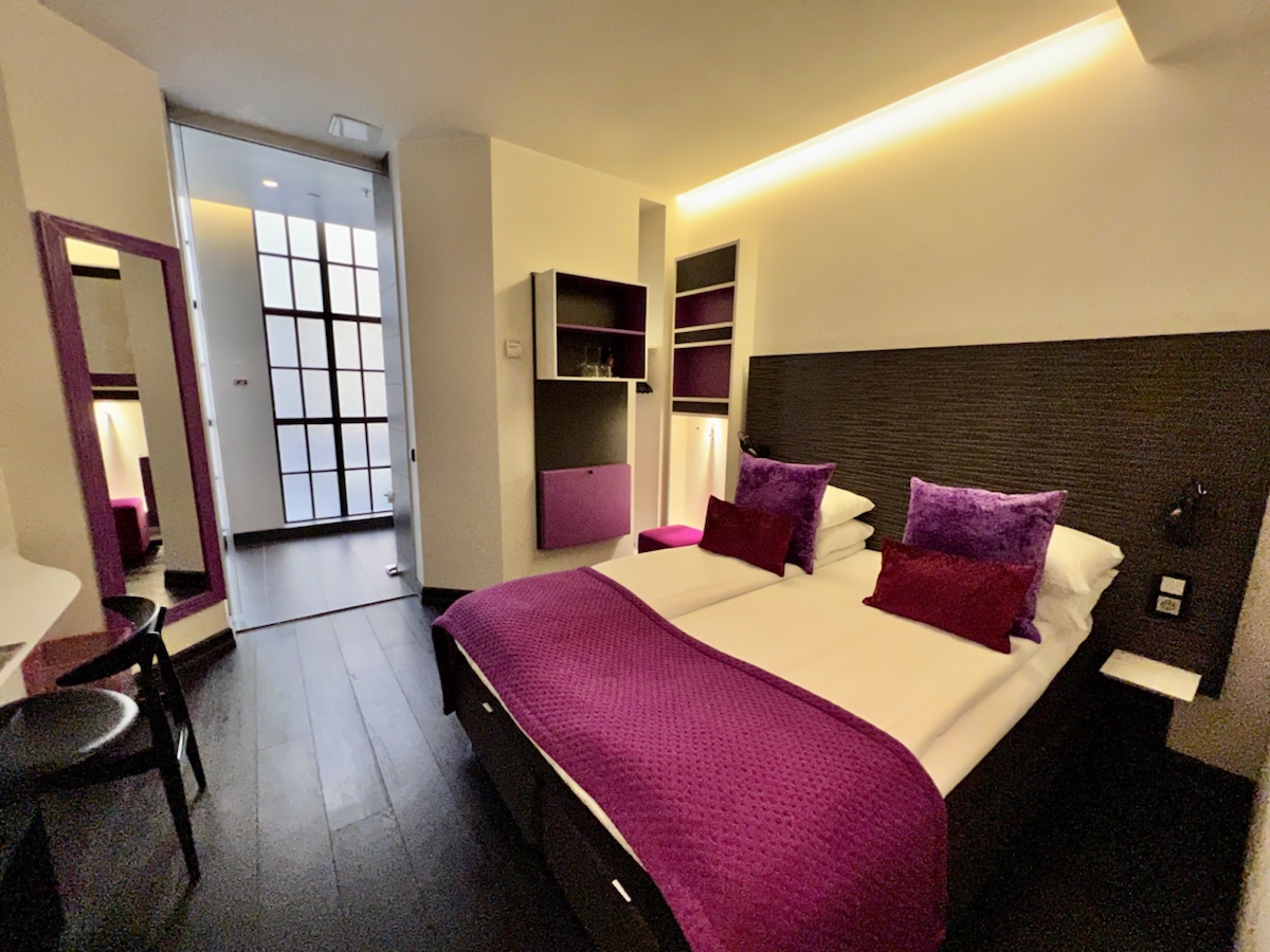 a bedroom with purple pillows and a bed