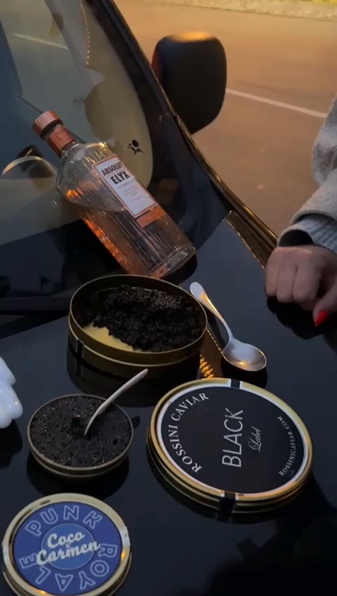 a bottle of alcohol and a can of black caviar on a table