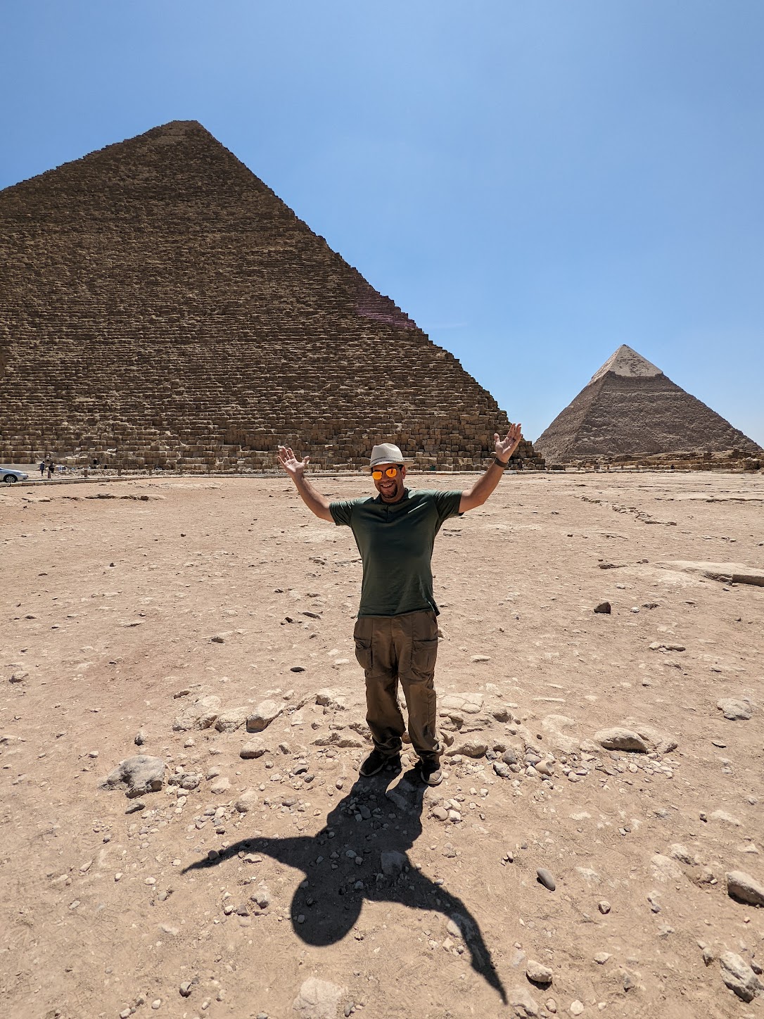 a man standing in front of a pyramid