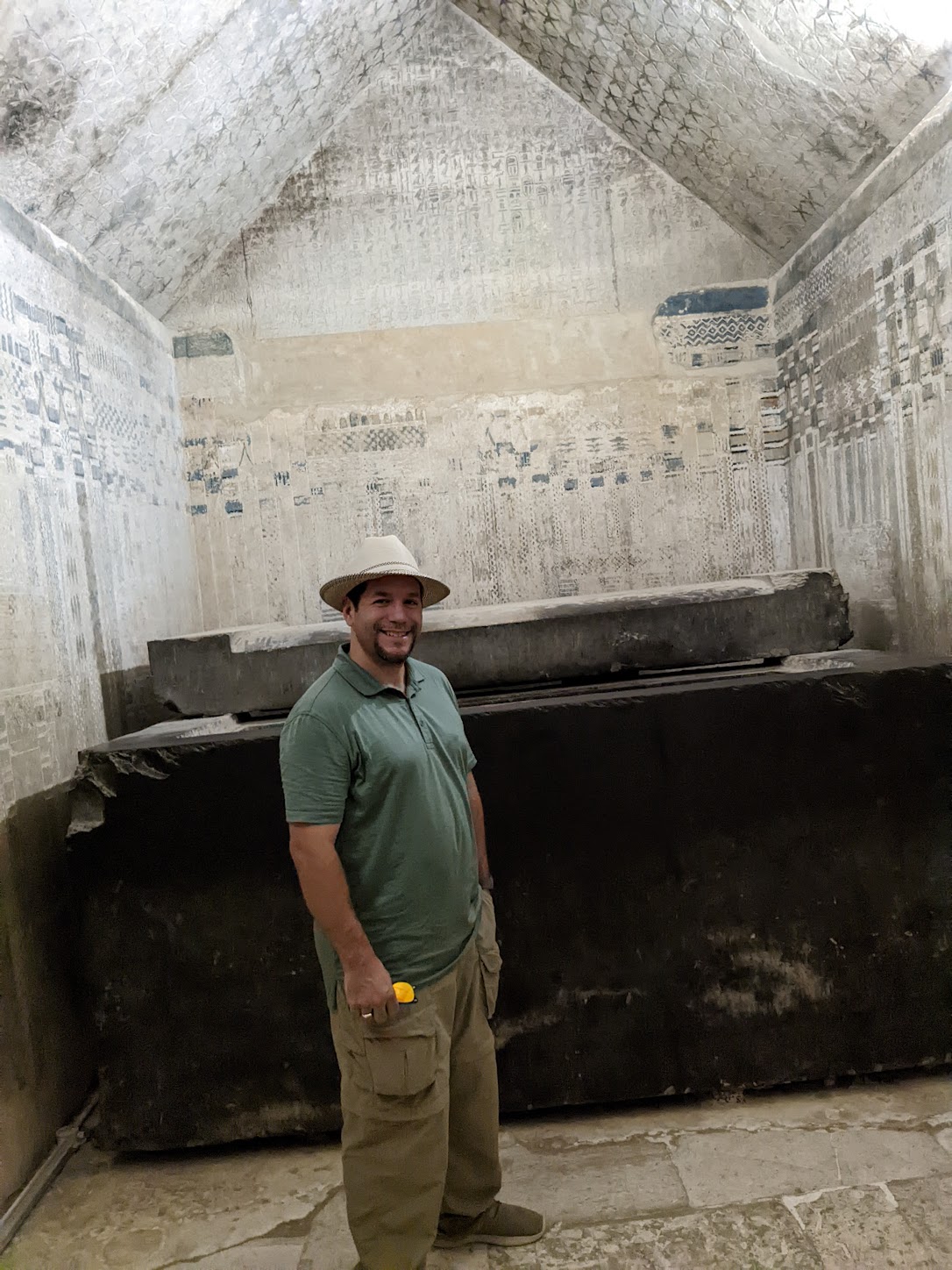 a man standing in a room with a stone structure
