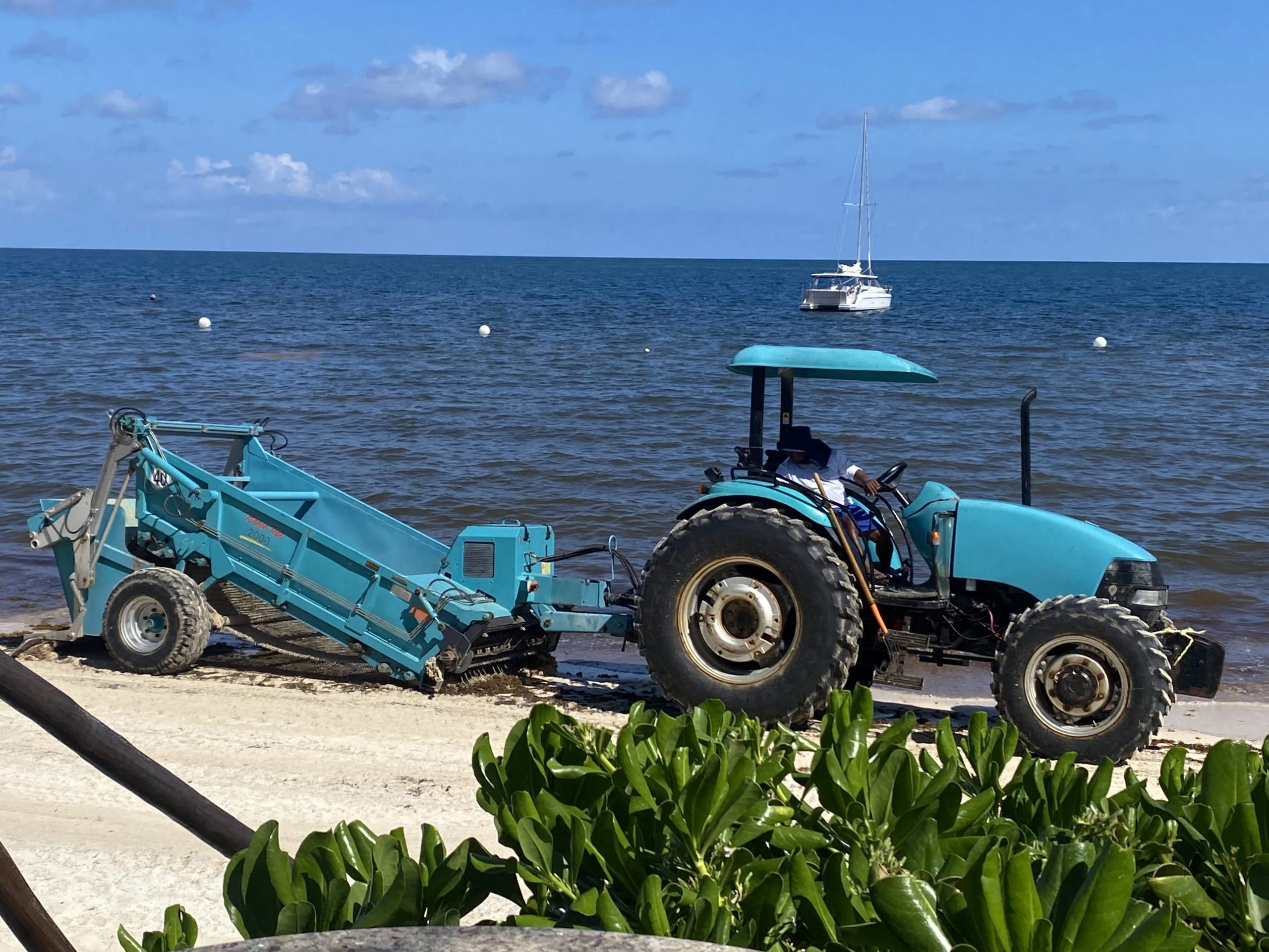 a tractor pulling a boat on a beach
