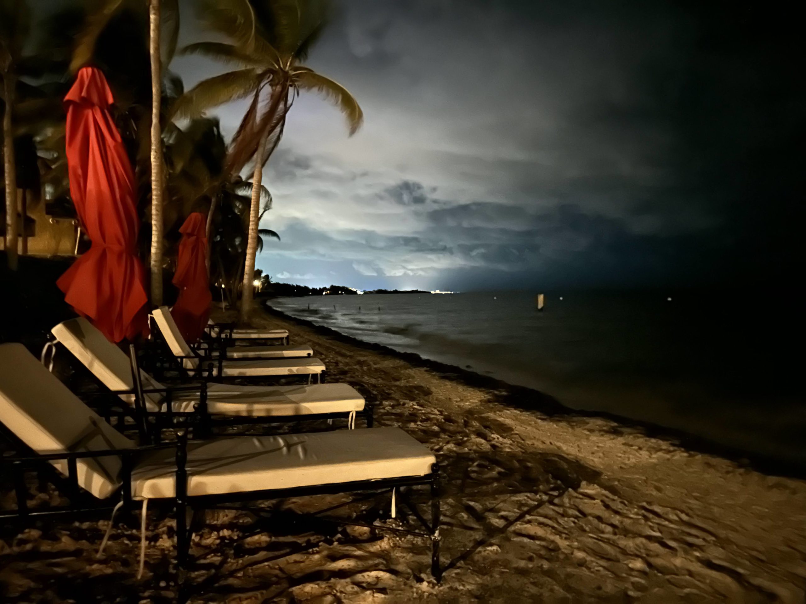 a beach chairs and umbrellas at night