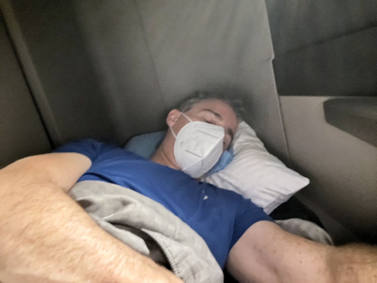 a man sleeping in a bed wearing a mask