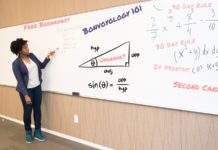 a woman writing on a whiteboard