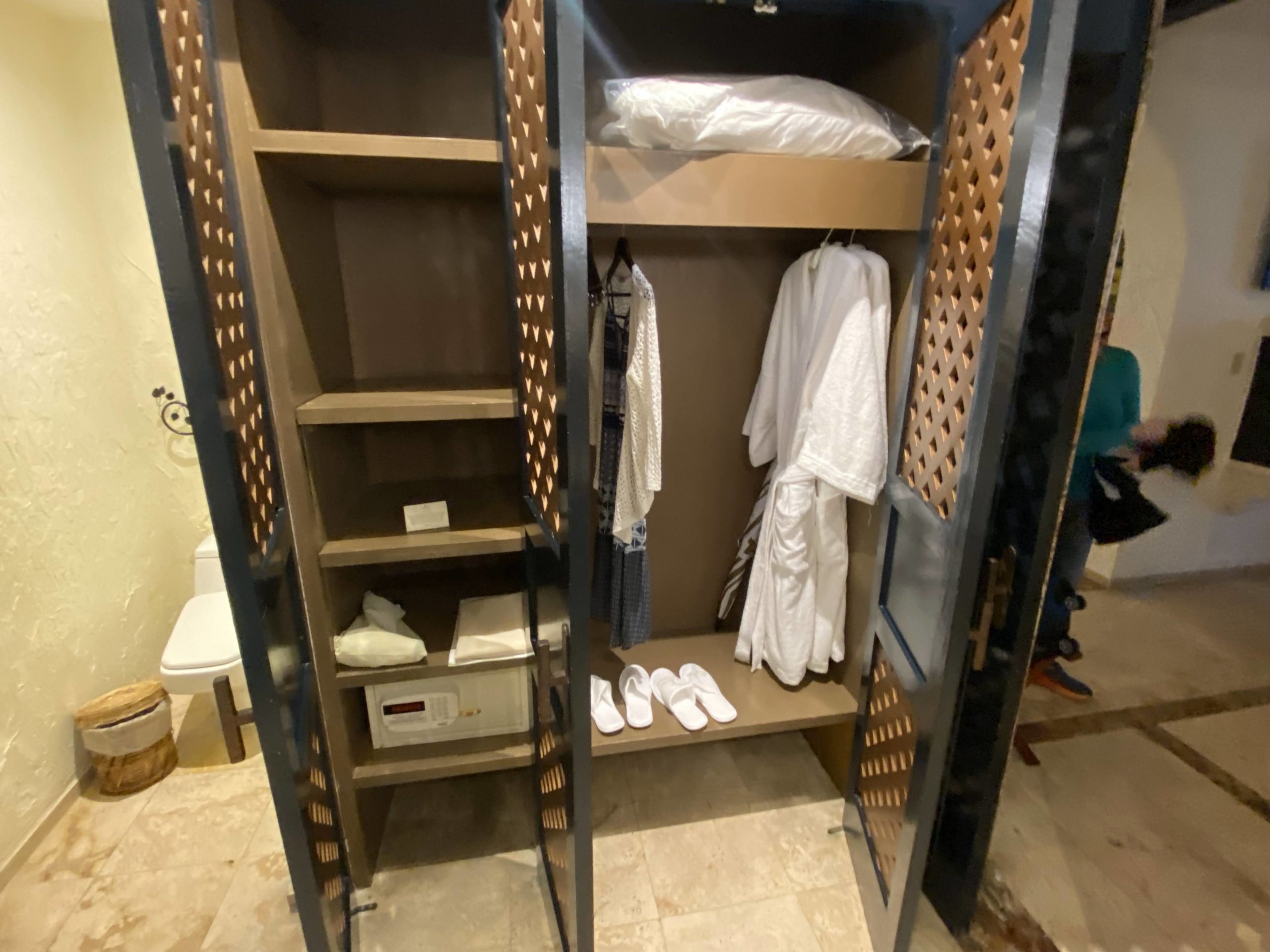 a closet with white robe and shoes