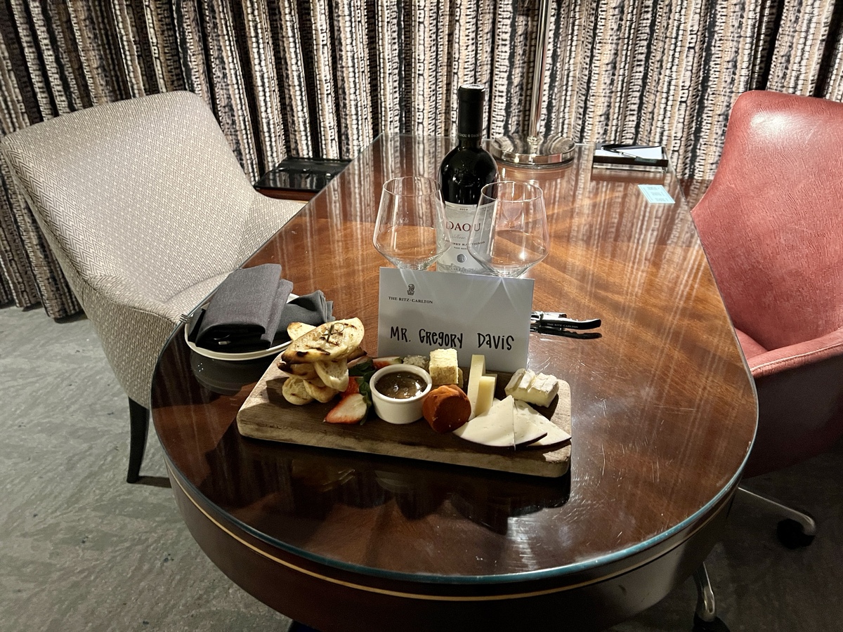 a table with a wine bottle and a tray of food