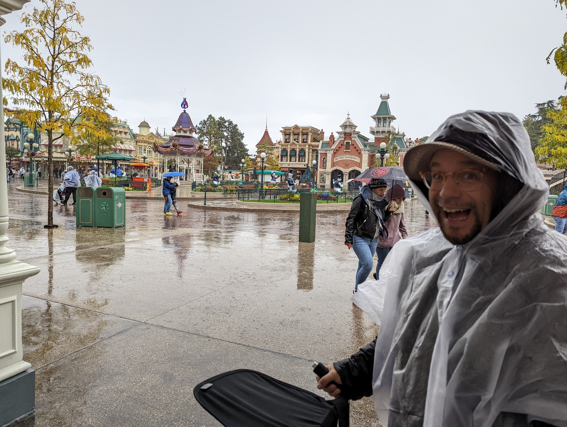 a man wearing a raincoat and smiling at the camera
