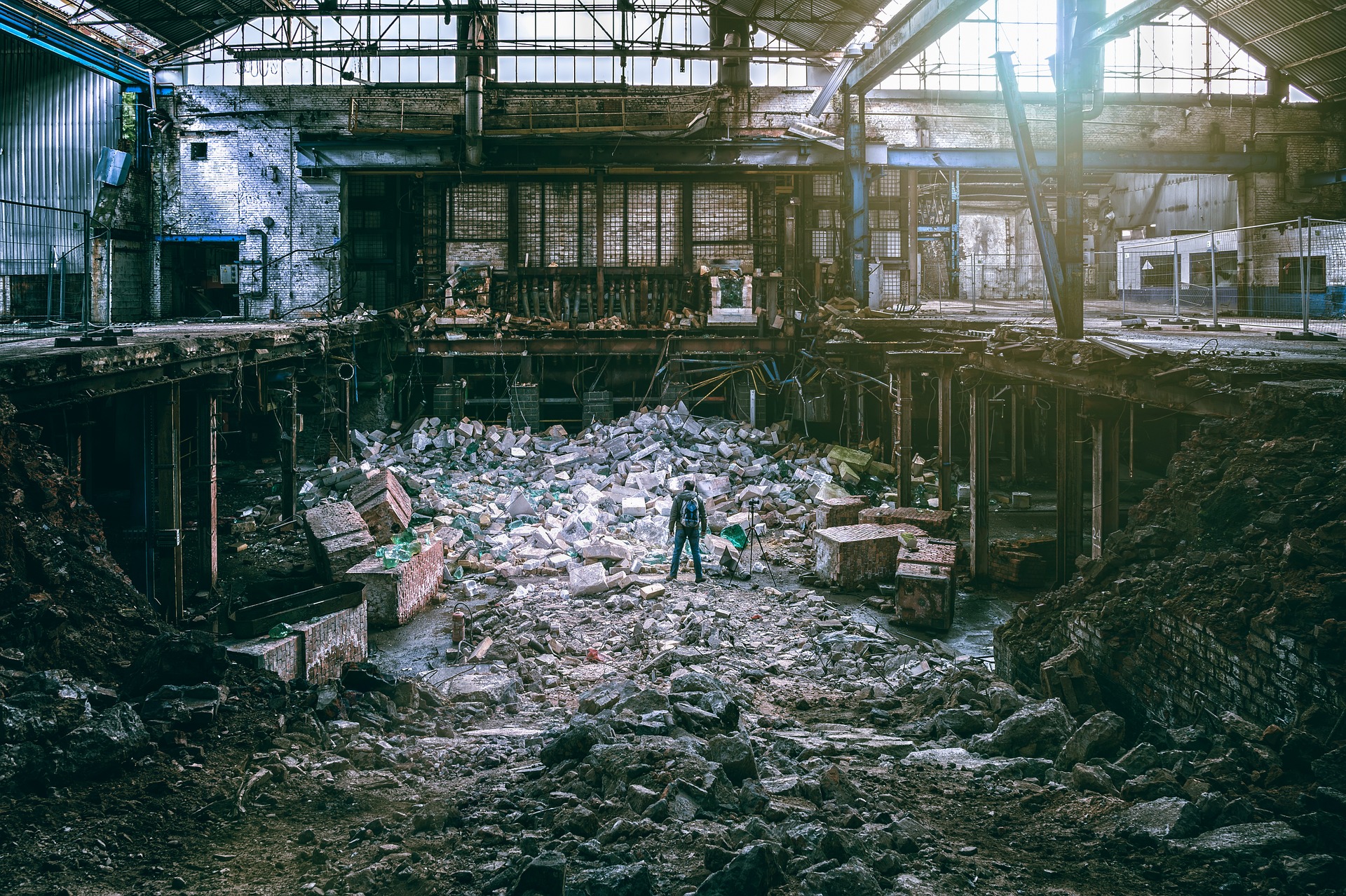 a person standing in a large room with rubble